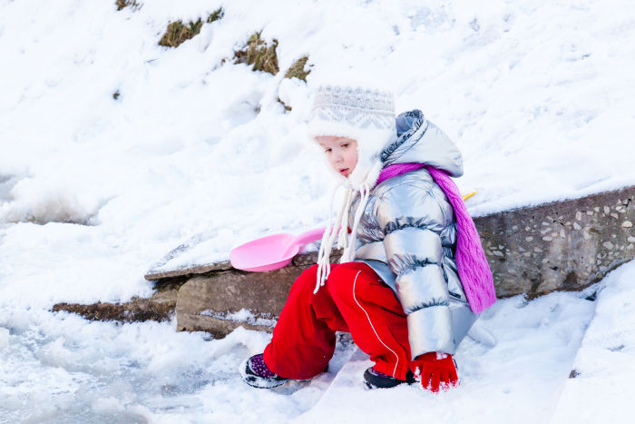 Little girl in snow with pink shovel