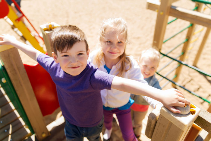 Three kids on a wooden playground