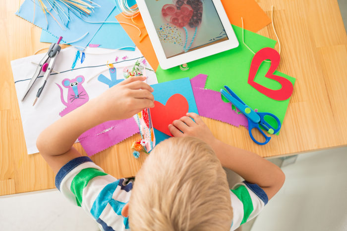 Little boy making a greeting card