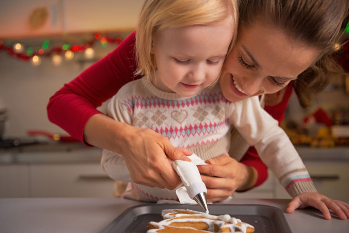 Little girl and her mother baking gingerbread men 