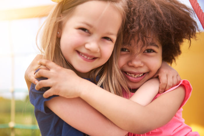 Little Caucasian and African American girls hugging