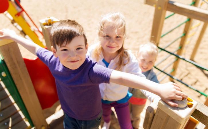 Three kids on a wooden playground