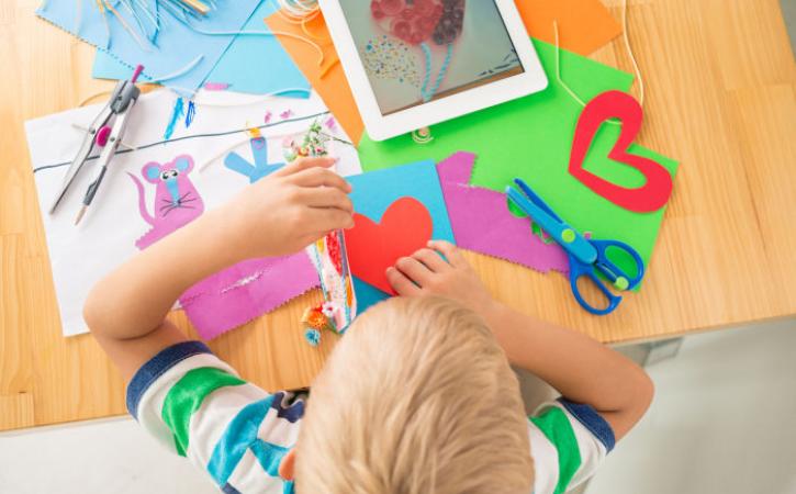 Little boy making a greeting card