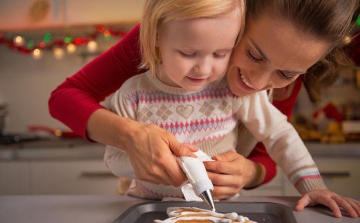 Little girl and her mother baking gingerbread men 