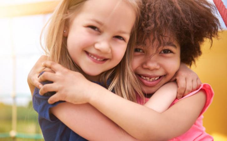 Little Caucasian and African American girls hugging